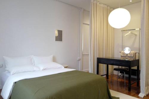 a bedroom with a bed and a desk with a lamp at Nap by Snooze in Bangkok