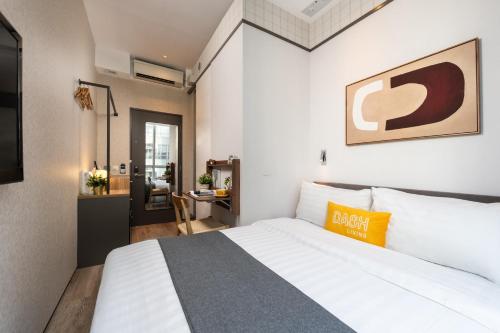 a bedroom with a large white bed and a desk at Dash Living on Queen's in Hong Kong