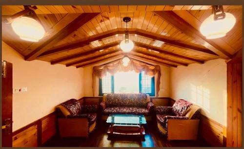 a living room with a couch and a table at Wintry homes 5 Bhk Villa in Shimla