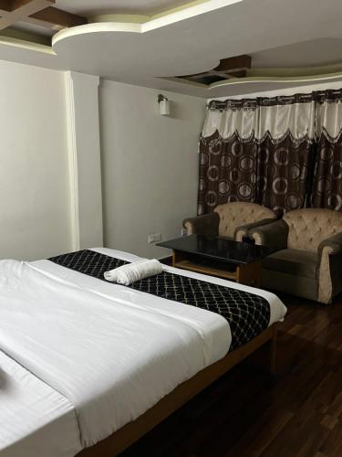 a hotel room with two beds and a chair at Wintry homes 5 Bhk Villa in Shimla