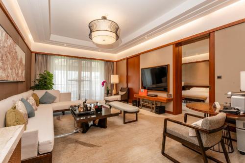 a living room with a couch and a tv at InterContinental Kunming by IHG in Kunming