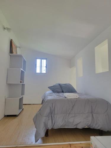 a bedroom with a bed in a white room at Casa en El Pinar in Ciudad de la Costa