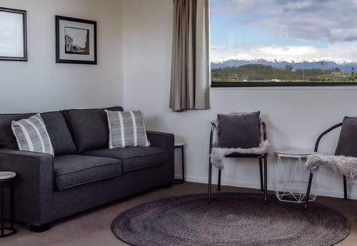 a living room with a couch and a chair at Sunset View Point in Hokitika