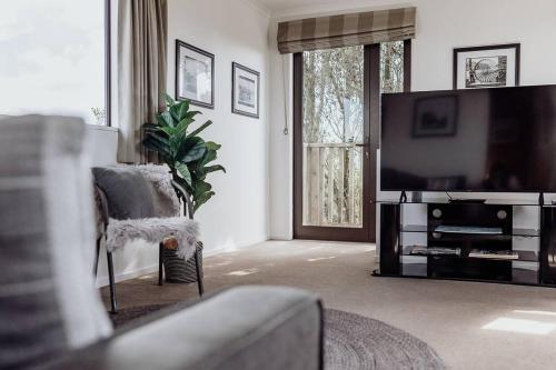 a living room with a large flat screen tv at Sunset View Point in Hokitika