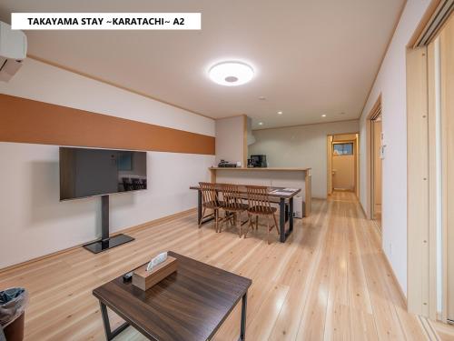 a living room with a table and a tv at Takayama Stay Karatachi in Takayama