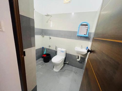 a bathroom with a toilet and a sink at Minty Homestay in Perumanseri