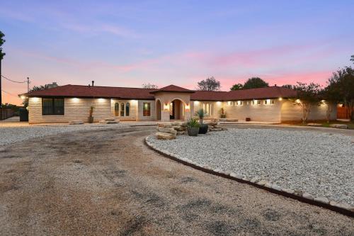 a house with a gravel driveway in front of it at Guadalupe Bluff Mediterranean in Kerrville