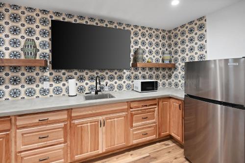 a kitchen with a sink and a tv on the wall at Guadalupe Bluff Mediterranean in Kerrville