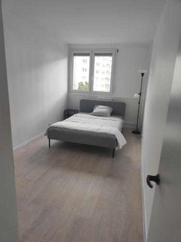 une chambre avec un lit et deux fenêtres dans l'établissement F4 neuf, à Saint-Étienne