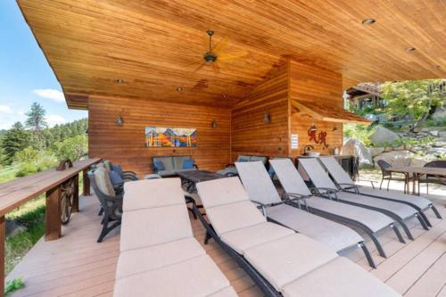 a deck with white chairs and a wooden ceiling at Red Roof Lodge - Leavenworth in Leavenworth