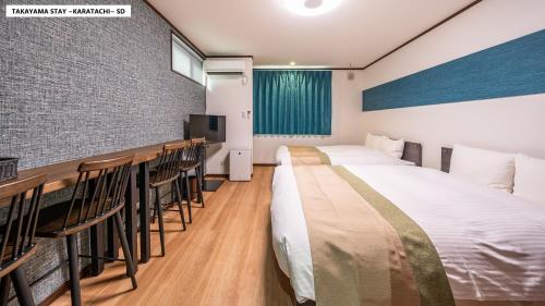 a hotel room with two beds and a bar at Takayama Stay Karatachi in Takayama