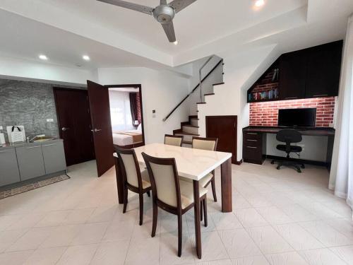 a dining room with a table and chairs and a staircase at Samui Sabai Haus mit Dachterrasse und Pool in Koh Samui 
