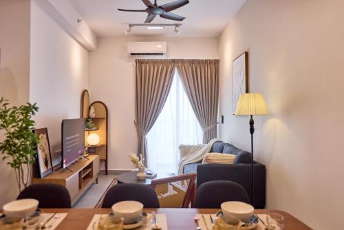 a living room with a table and chairs and a television at Sunsuria Forum SOHO & Residence Suites Setia Alam by MOKA in Shah Alam