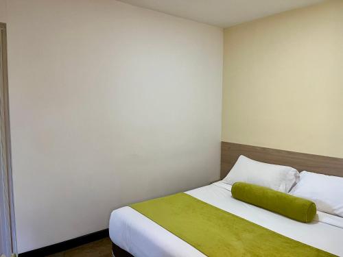a bedroom with a bed with a green pillow on it at Room in BB - Suite Presidencial en hotel proximo al aeropuerto in San Antonio de Pereira