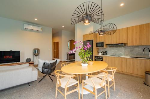 a kitchen and a living room with a table and chairs at Modern 4BR Villa with Private Pool in Bangtao in Bang Tao Beach