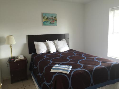 a bedroom with a bed with a black and white comforter at Port Isla Inn in Port Isabel