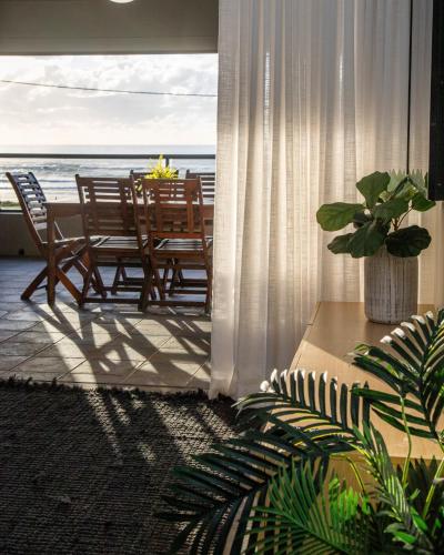 a living room with a table and chairs and the ocean at Lennox Holiday Apartments in Lennox Head