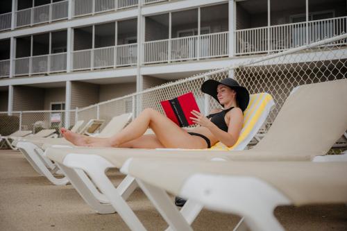a woman sitting on a beach chair reading a book at Bayshore Resort At Put-In-Bay in Put-in-Bay