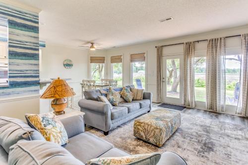 a living room with two couches and windows at Walk to Marina Pet-Friendly Little River Home! in Little River