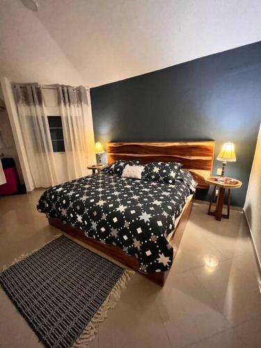 a bedroom with a bed with a black and white blanket at Departamento Rubi en Diamante Lakes in Acapulco