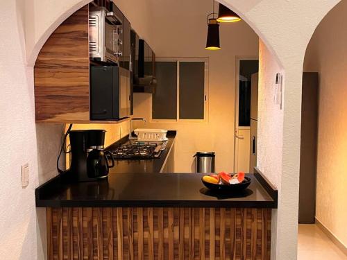 a kitchen with a counter with a bowl of fruit on it at Departamento Rubi en Diamante Lakes in Acapulco