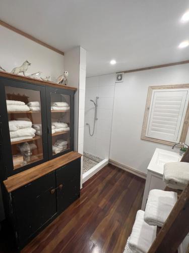 ein Badezimmer mit Waschbecken und einem Regal mit Handtüchern in der Unterkunft Base Camp Cottage in Taupo