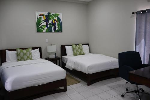 a hotel room with two beds and a desk and a desk at The Toucan Inn in Independence