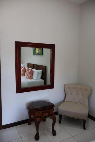 a bedroom with a mirror and a chair and a table at The Toucan Inn in Independence