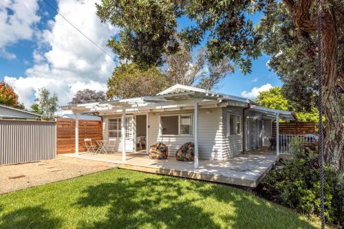 a small white house with a yard at Miami one one in Oneroa