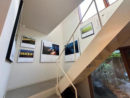a staircase with pictures on the wall at WGJ Hostel Kyoto in Nishi-kujō-Toriiguchichō