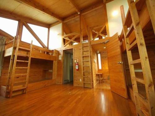 ein großes Zimmer mit Etagenbetten und Holzböden in der Unterkunft Towada City Utarube Campsite - Vacation STAY 00407v in Utarube