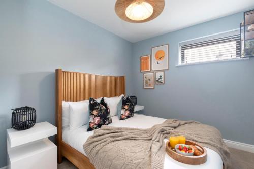 a bedroom with a bed with a tray of food on it at Elliot Oliver - Beautiful Two Bedroom Apartment With Parking in The Docks in Gloucester