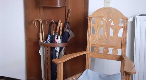 a wooden shelf with umbrellas and a wooden chair at Atelierhaus Tannenweg in Worpswede
