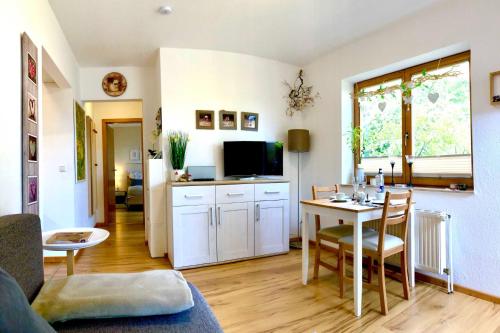 a living room with a table and a kitchen at Ferienwohnung Worpswede am Berg in Worpswede