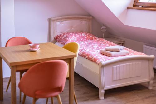 a small bedroom with a bed and a table at Penzion Benátky in Pelhřimov