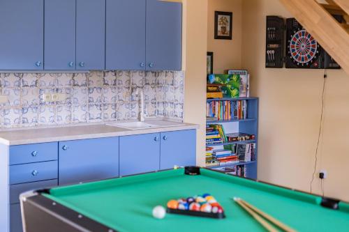 a pool table in a kitchen with blue cabinets at Penzion Benátky in Pelhřimov