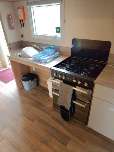 a kitchen with a stove and a counter top at The Pearl - Deluxe Access Caravan in Skegness