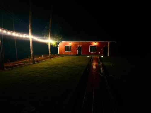 a building lit up at night with lights at Pingara The village retreat in Udupi