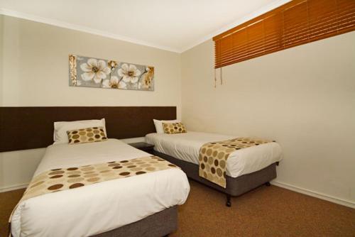 Tempat tidur dalam kamar di Mandurah Motel and Apartments