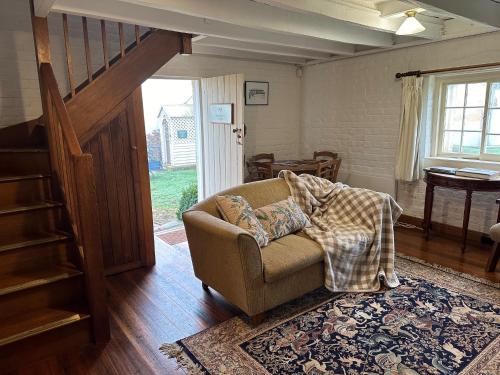 a living room with a couch and a staircase at Woolmers Estate in Longford