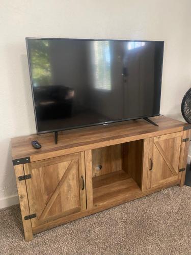 a large flat screen tv on a wooden entertainment center at Entire Tiny House with Large Yard Fenced In! in West Valley City