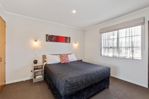 a bedroom with a bed and a window at Knightsbridge Court Motor Lodge in Blenheim
