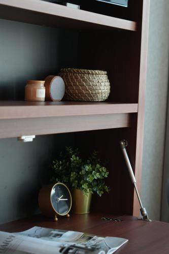 a shelf with a clock and a plant on a desk at Dash Living on Queen's in Hong Kong