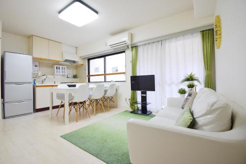 a living room with a white couch and a kitchen at Hostel Inn Tokyo Ryogoku in Tokyo