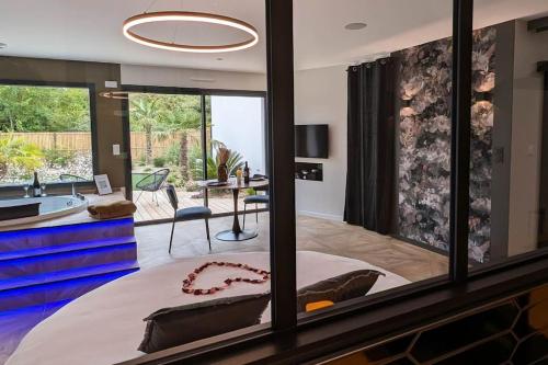 a bedroom with a large bed and a large window at Les Suites du Payré - Suite Passion in Talmont