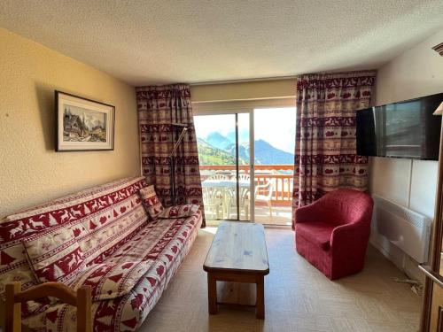 un salon avec un canapé, une table et une télévision dans l'établissement Appartement 4-6 pers Plein sud, à L'Alpe-d'Huez