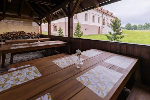 a patio with wooden tables and a view of a building at Penzion Benátky in Pelhřimov
