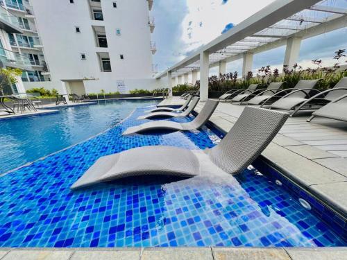 une piscine avec des chaises longues et une piscine dans l'établissement 19 Cityscape Views, à Cari Mayor