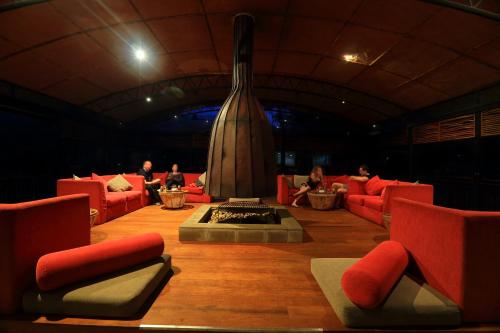 a living room with red couches and a fireplace at The Rainforest Ecolodge - Sinharaja with Shuttle Service from Car Park in Deniyaya