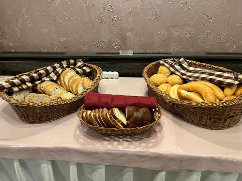 three baskets of bread sitting on a table at Park Hotel Gyula in Gyula